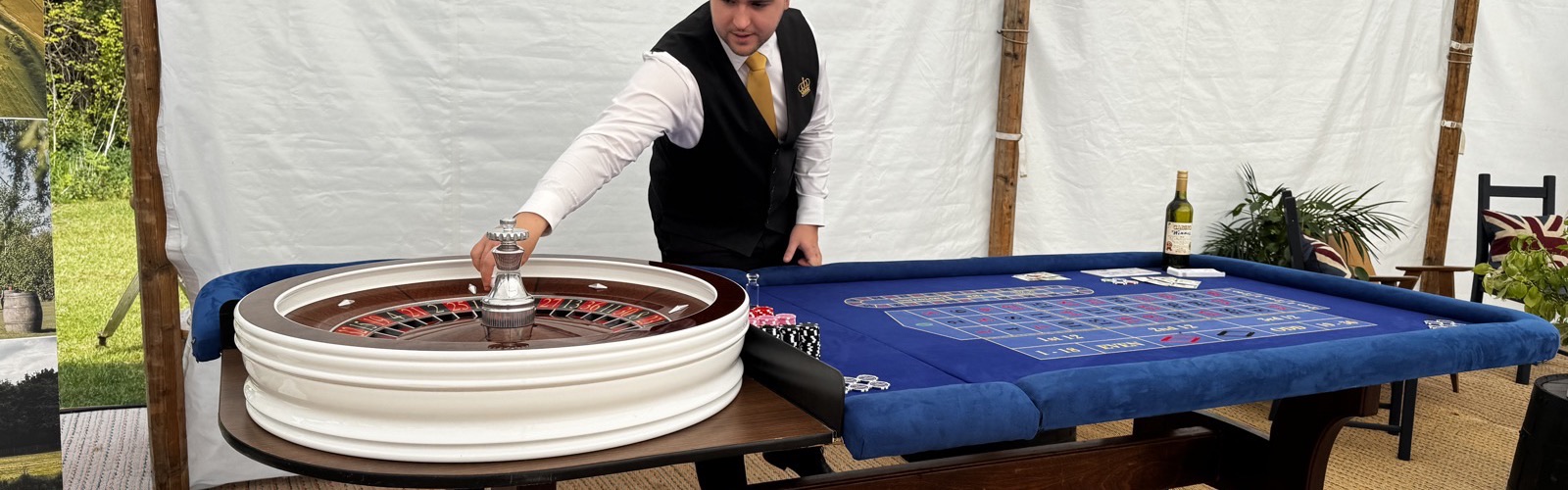 A Royale croupier setting up the roulette wheel inside a marquee