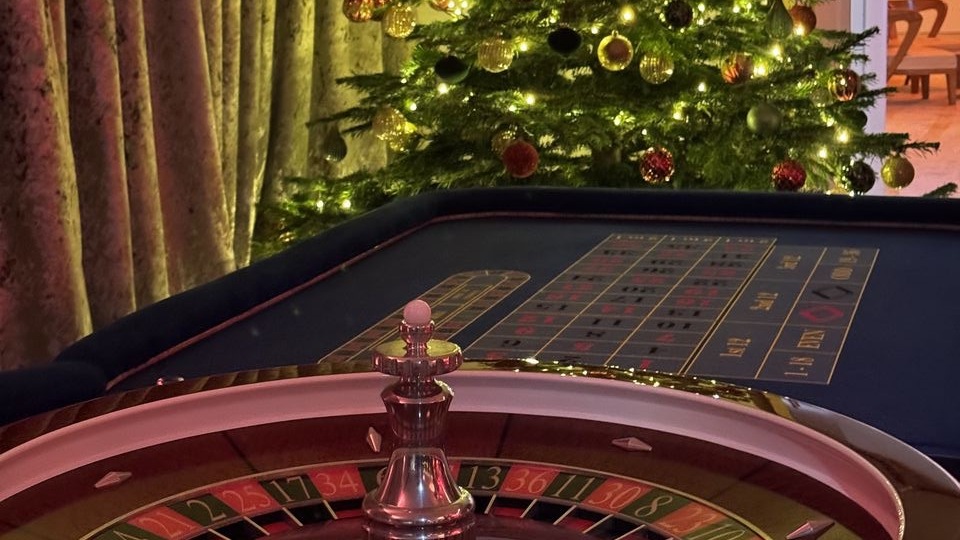 A roulette wheel dressed with festive foliage and fairy lights at a Christmas party