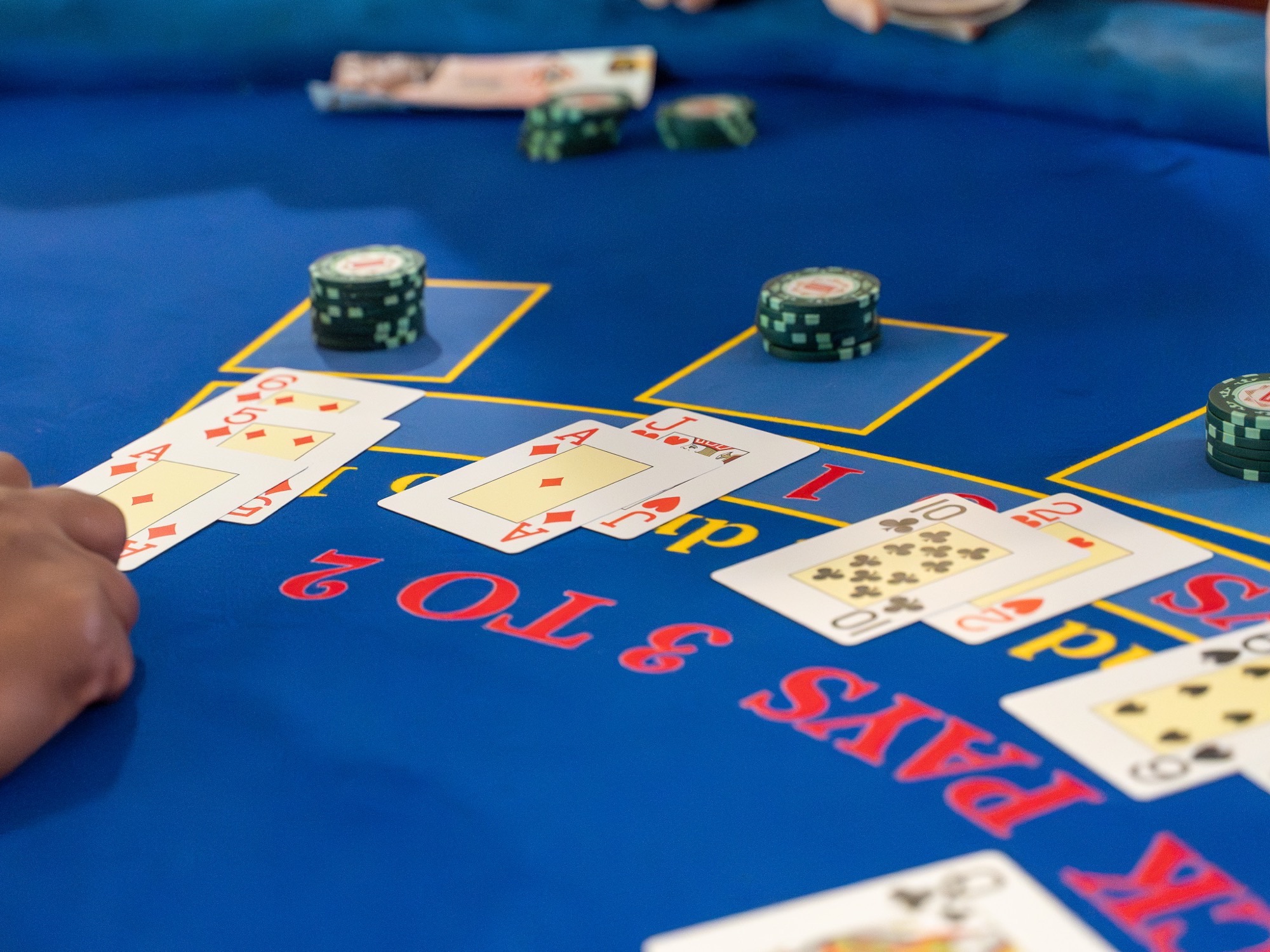 An ace and jack dealt on a blackjack cloth reading Pays 3 to 2