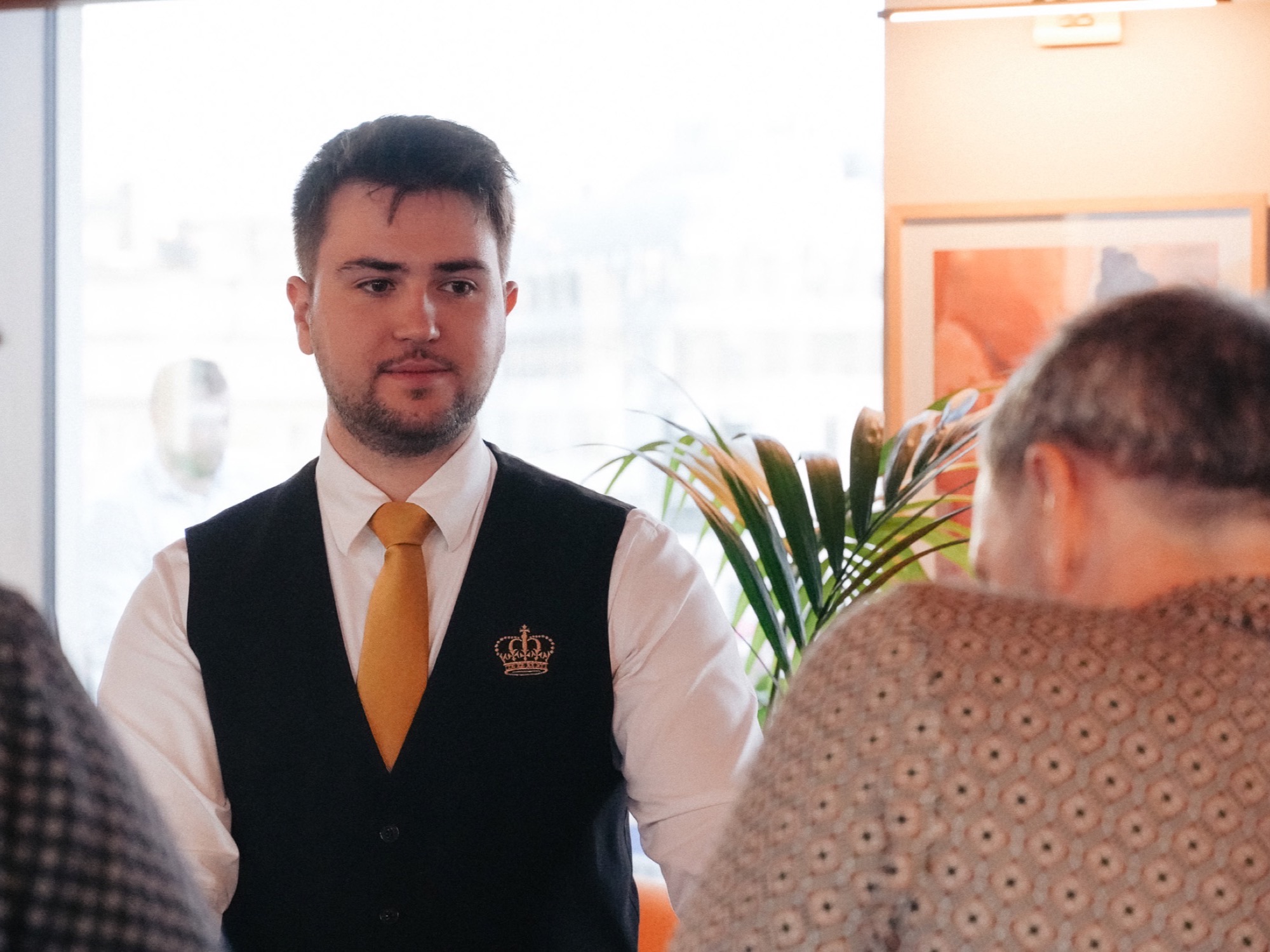 A Royale croupier in the crown-embroidered waistcoat and gold tie