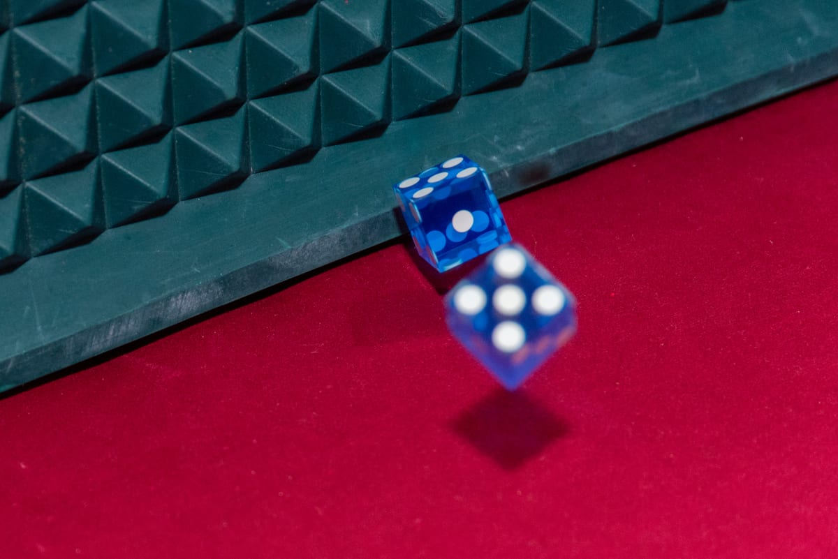 Dice in mid-air over a red craps layout