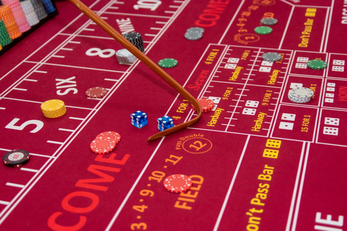 Dice and chips on a red craps layout with the stick in play