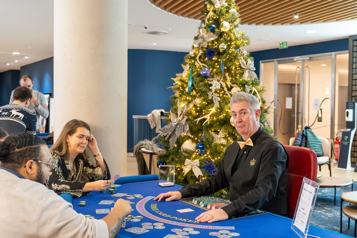 Our croupier dealing Three Card Poker beside a Christmas tree