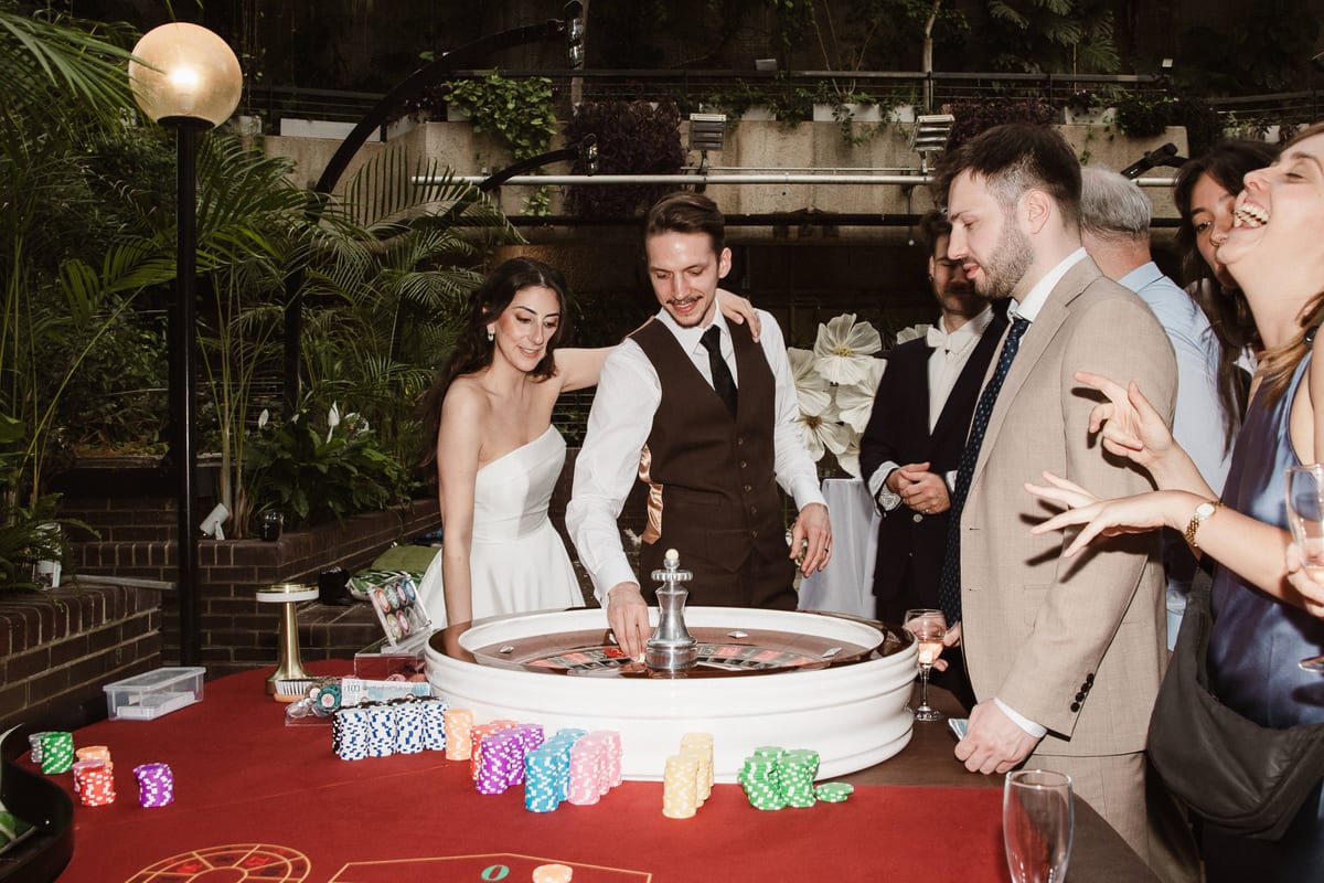 A bride and groom spinning the roulette wheel with their guests