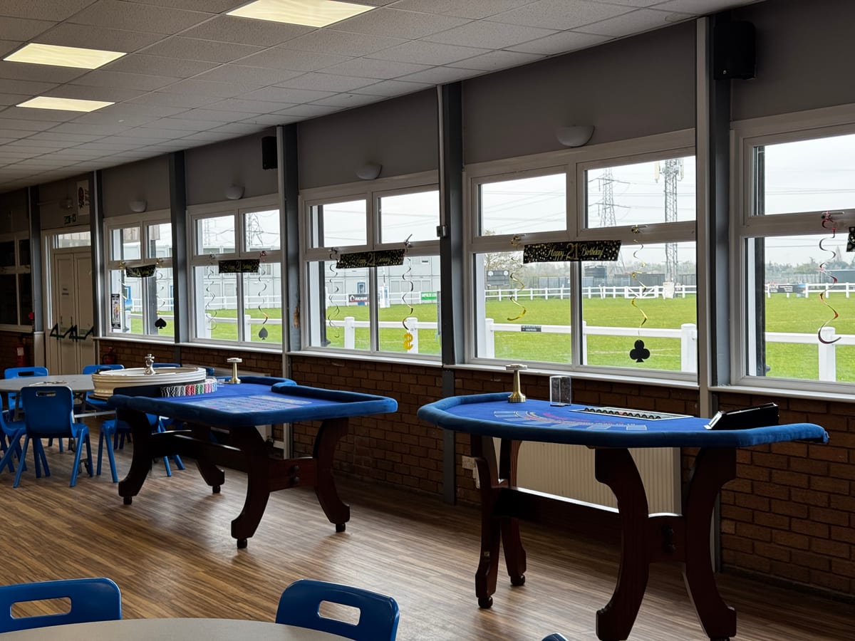 Blackjack and roulette tables set up by the windows of a racecourse suite