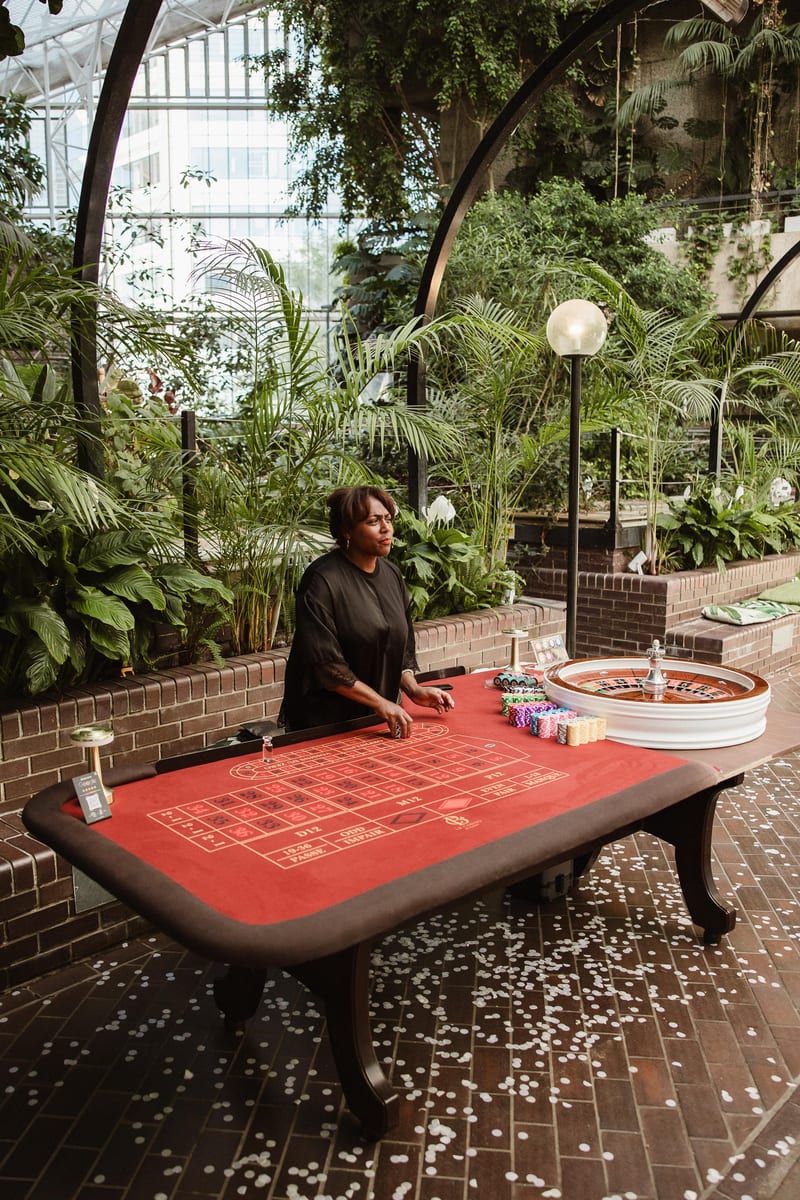 Our croupier ready at a red roulette table in a garden conservatory