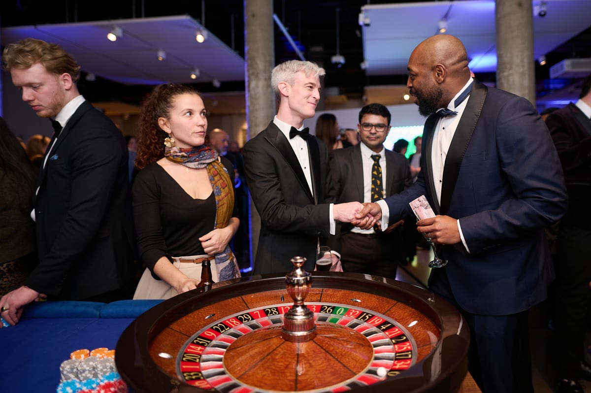 Guests in black tie gathered round the roulette wheel