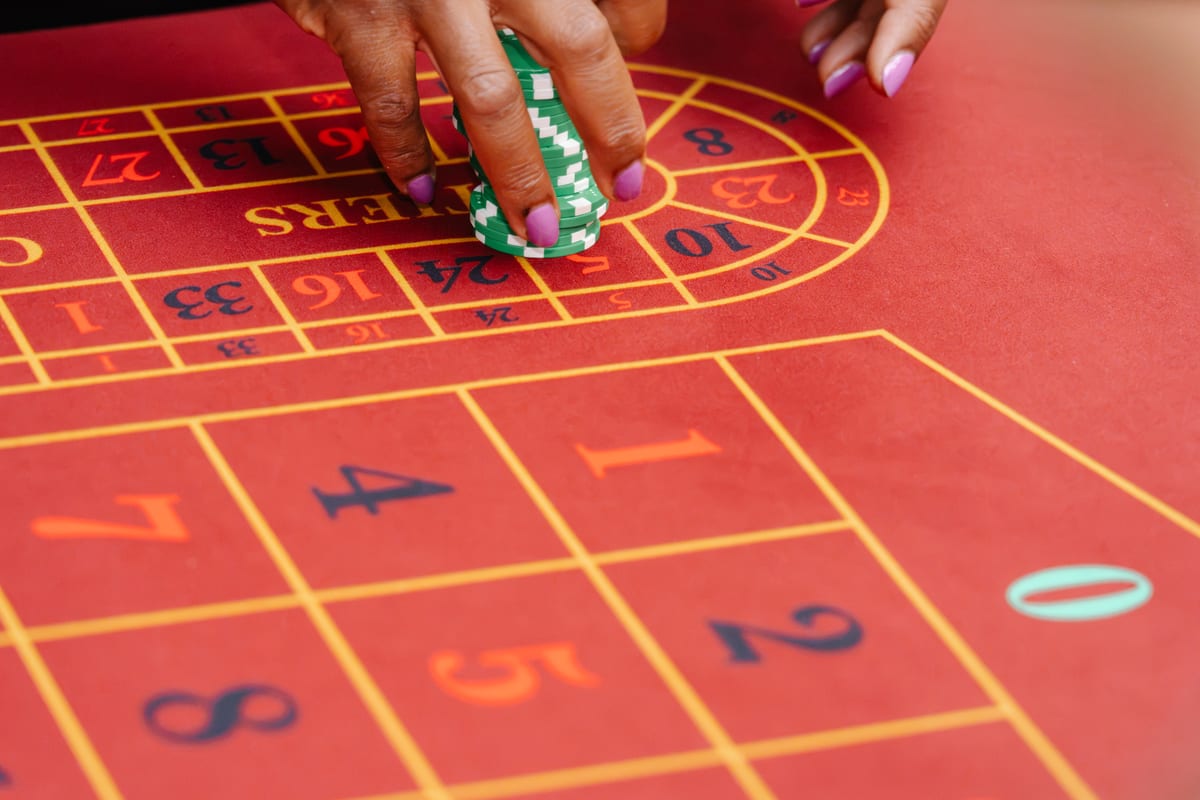 A guest placing a stack of chips on the red roulette layout