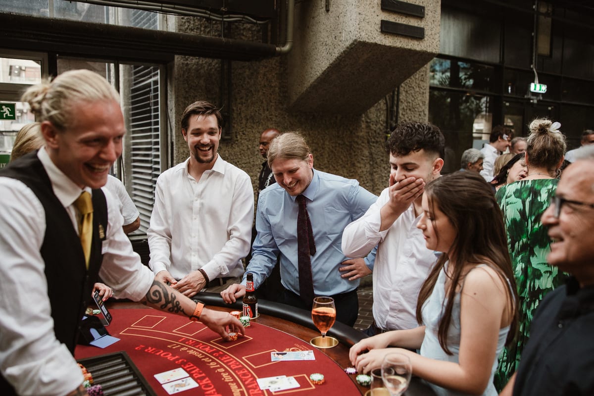 Our croupier sharing a laugh with guests at a red blackjack table