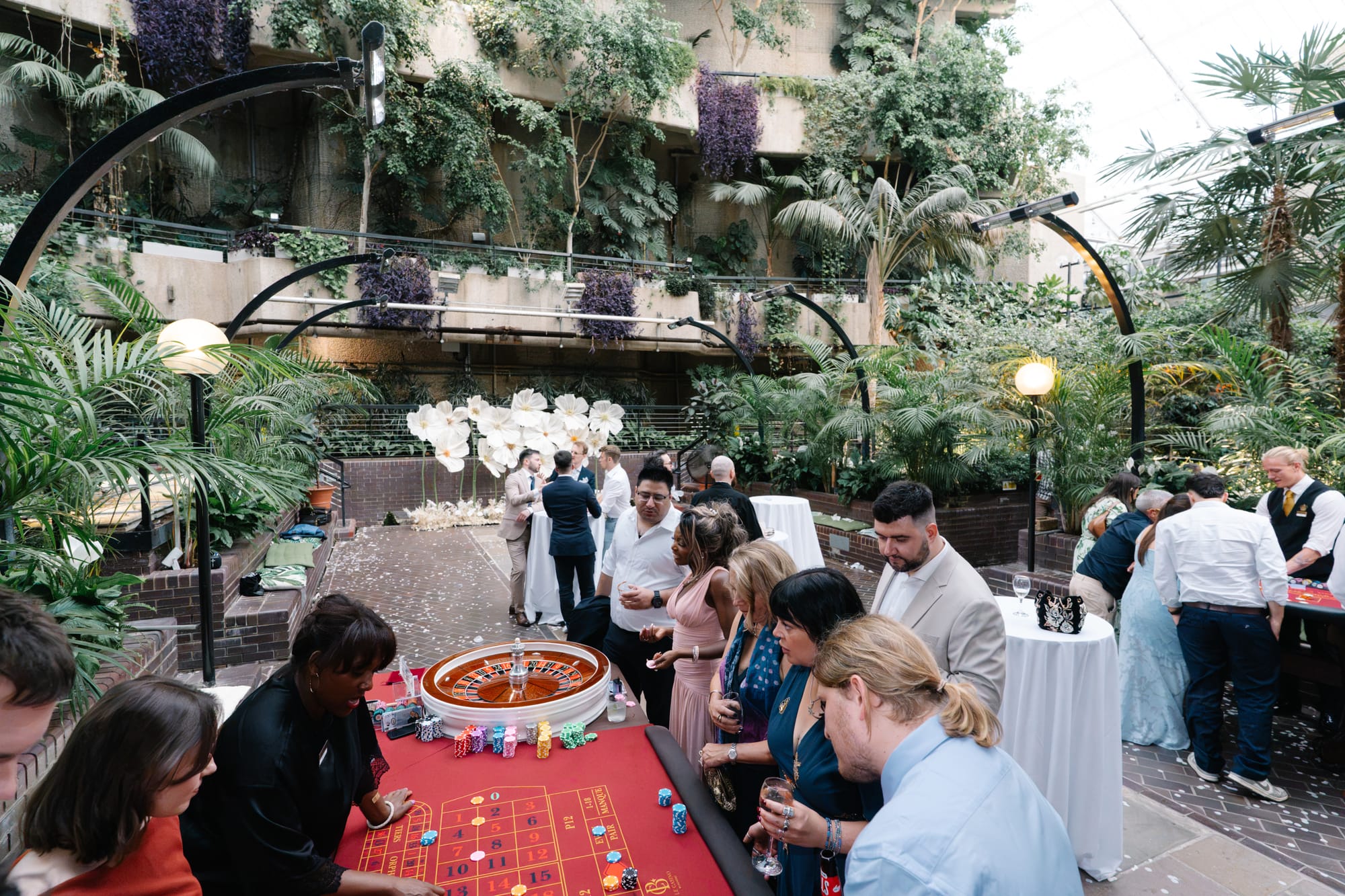 Guests gathered round a Royale table in a garden conservatory
