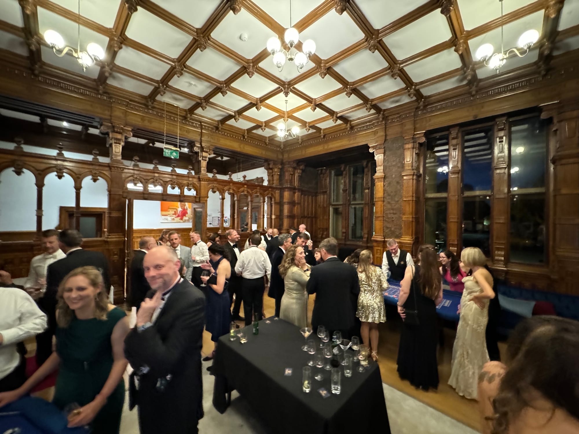 Guests in black tie filling an oak-panelled hall on a Royale casino night