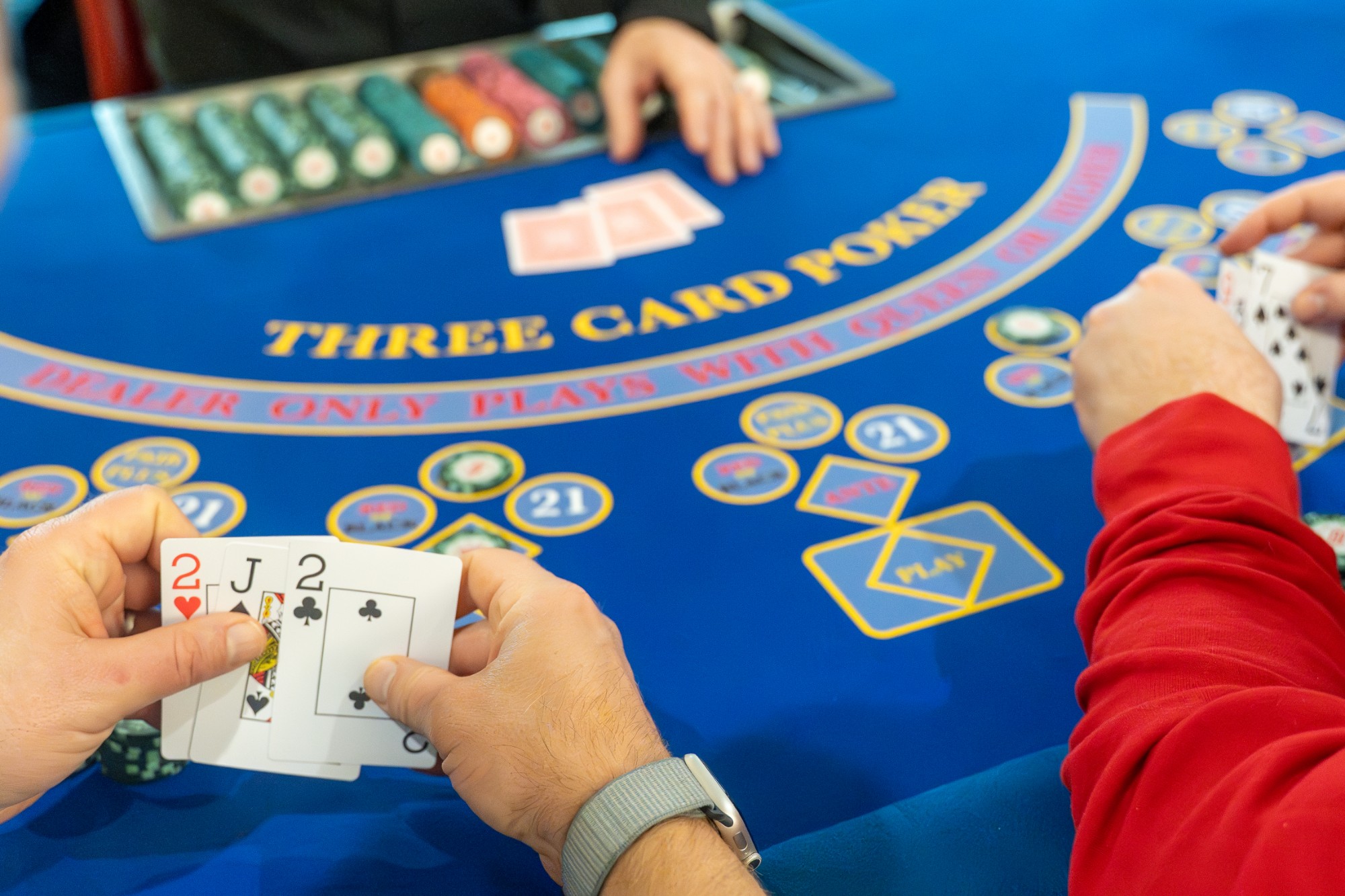 A Royale three card poker table mid-hand, players holding their cards